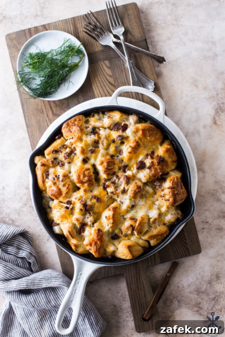 A close-up shot of the finished Cheesy Shrimp Skillet Monkey Bread, with steam gently rising, highlighting its bubbly cheese and golden-brown crust.