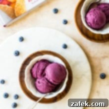 Velvet Blueberry Ice Cream 7 Overhead photo of white dishle board filled with dark purple blueberry ice cream on round marb
