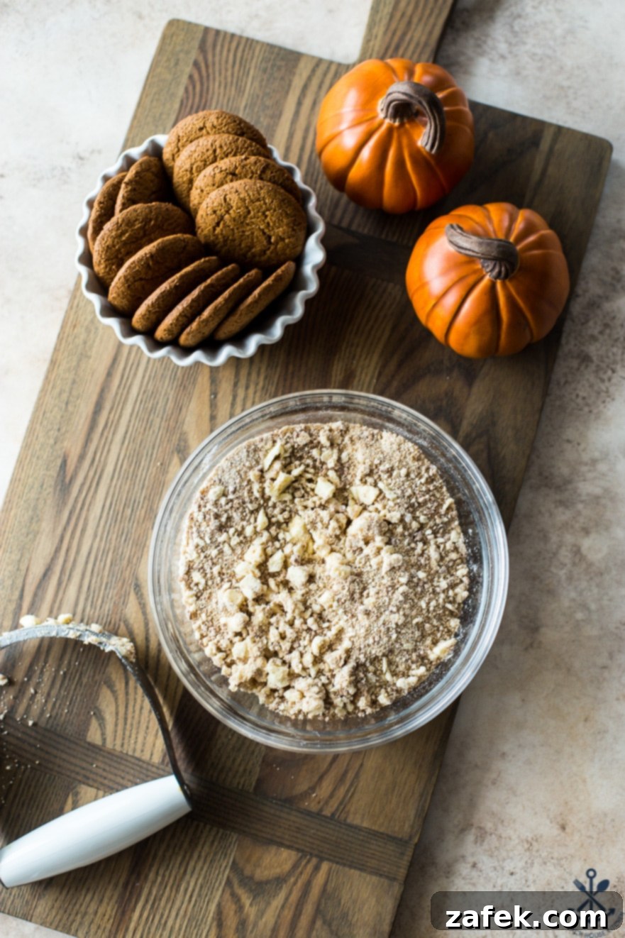 Spiced Pumpkin Custards with Gingersnap Crumble 7 Ingredients for the gingersnap crumble, including crushed gingersnaps, flour, and butter, combined in a bowl with a pastry blender on a wooden surface.