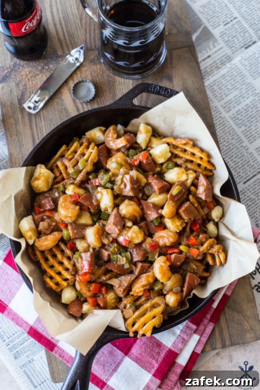 Bayou Poutine 3 Overhead photo of Cajun poutine in a skillet on a wooden board