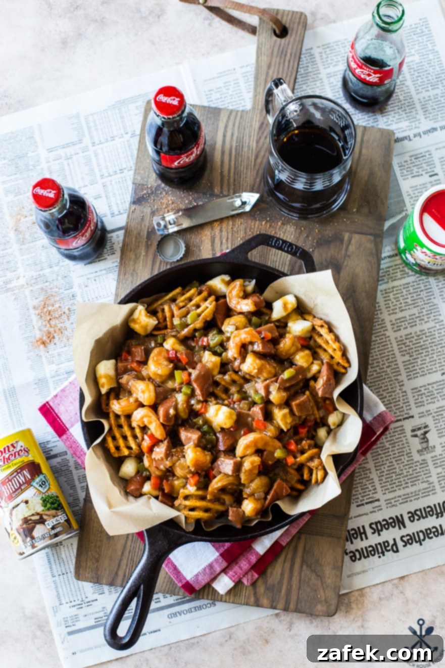 Bayou Poutine 7 Overhead photo of Cajun poutine in a skillet on a wooden board