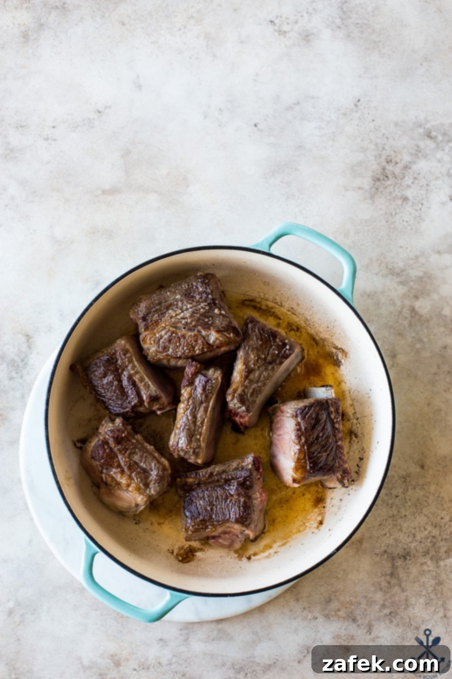 Unforgettable Short Rib Ragù Unmissable Giveaway 5 A Dutch oven filled with perfectly browned beef short ribs, a crucial first step for developing rich flavor in any ragu.