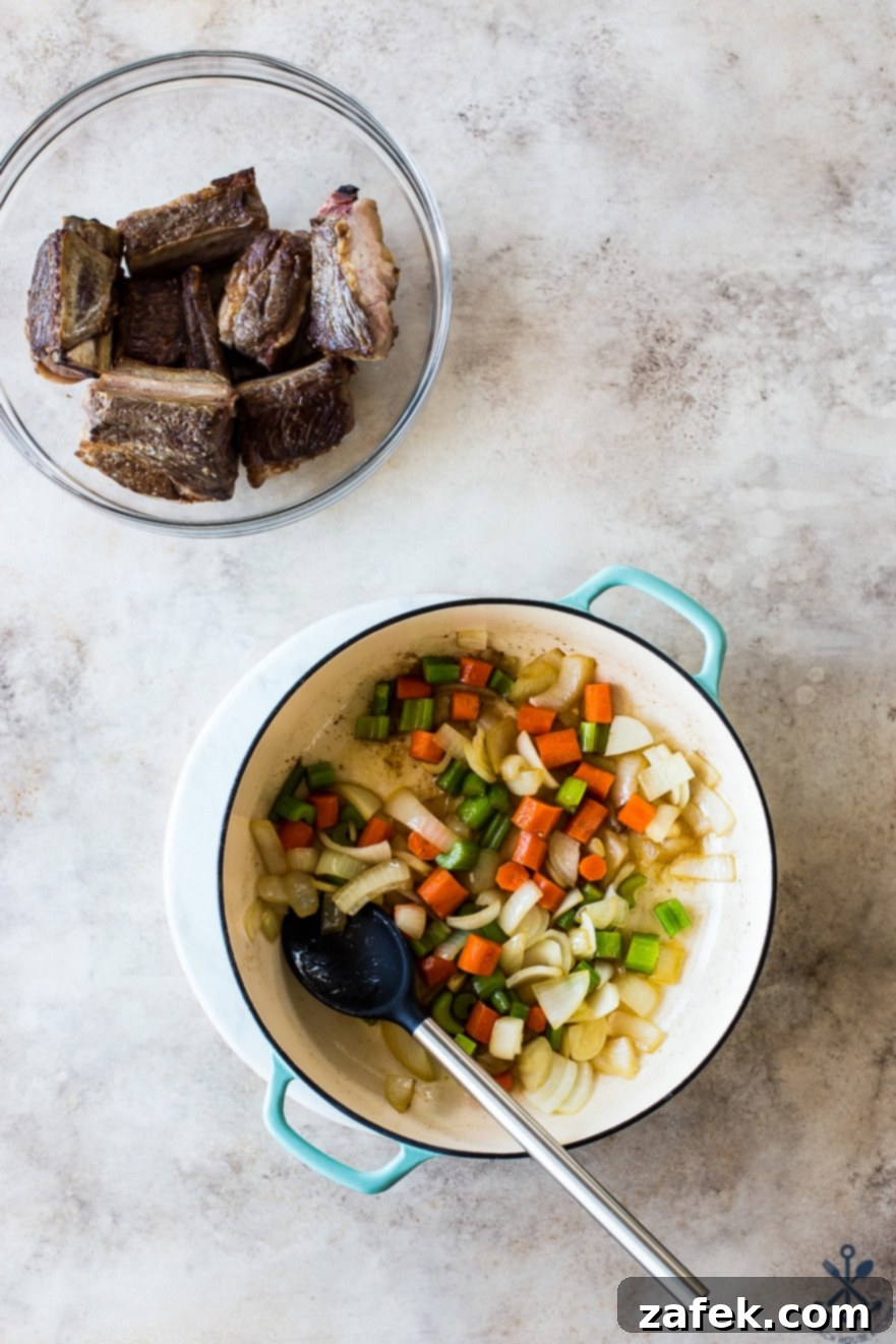Unforgettable Short Rib Ragù Unmissable Giveaway 6 Prepped ingredients for Short Rib Ragù, including diced carrots, celery, and onions in a Dutch oven, with a bowl of seasoned short ribs ready to be added.
