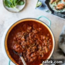 Unforgettable Short Rib Ragù Unmissable Giveaway 9 Slow-Cooked Short Rib Ragù in a Dutch oven with fresh basil leaves for garnish, a perfect image for a delicious recipe.