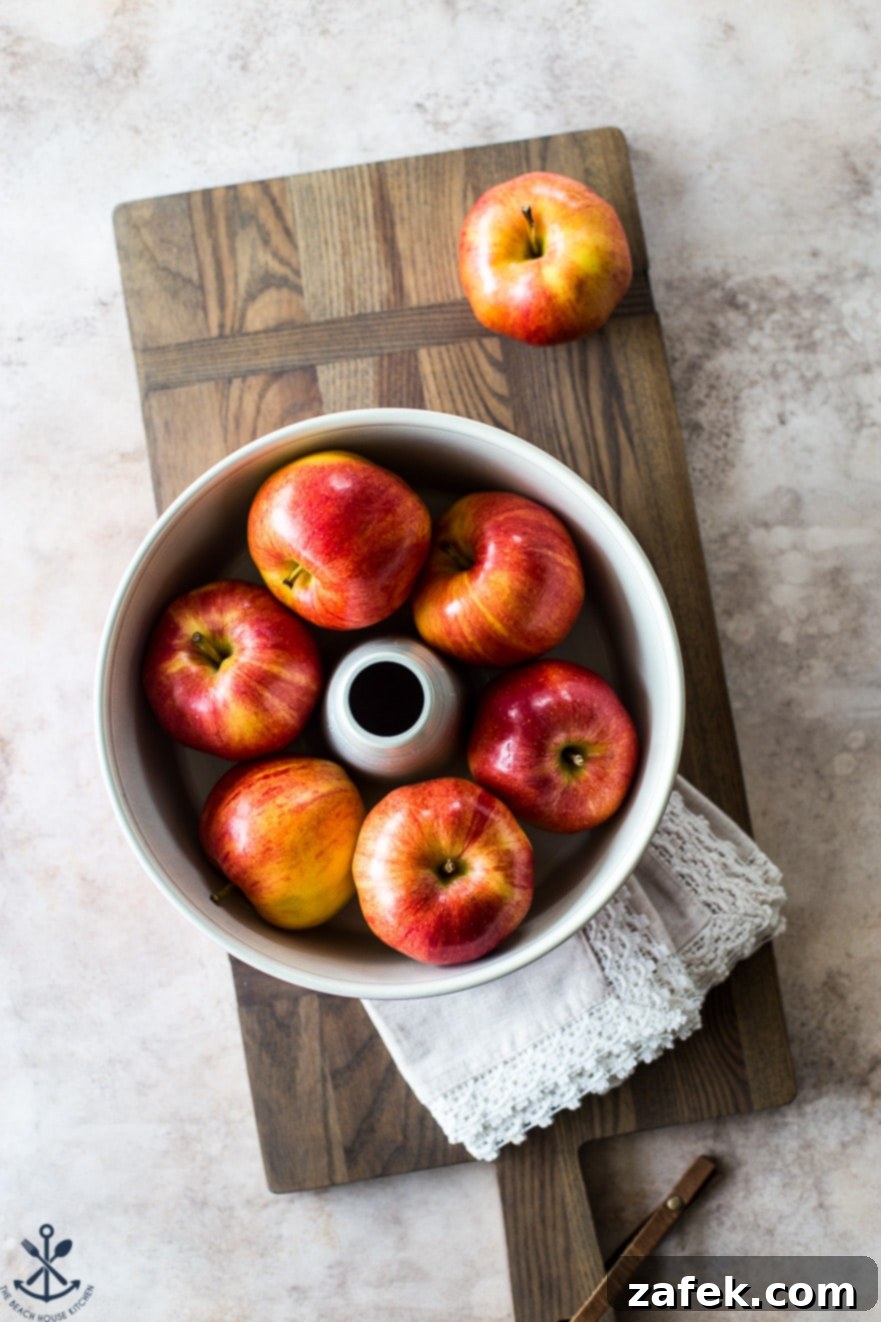 Old Fashioned Apple Spice Cake 8 Vibrant red apple chunks beautifully arranged in a tube pan, ready to be layered into the Jewish Apple Cake batter, creating an enticing visual of the ingredients.