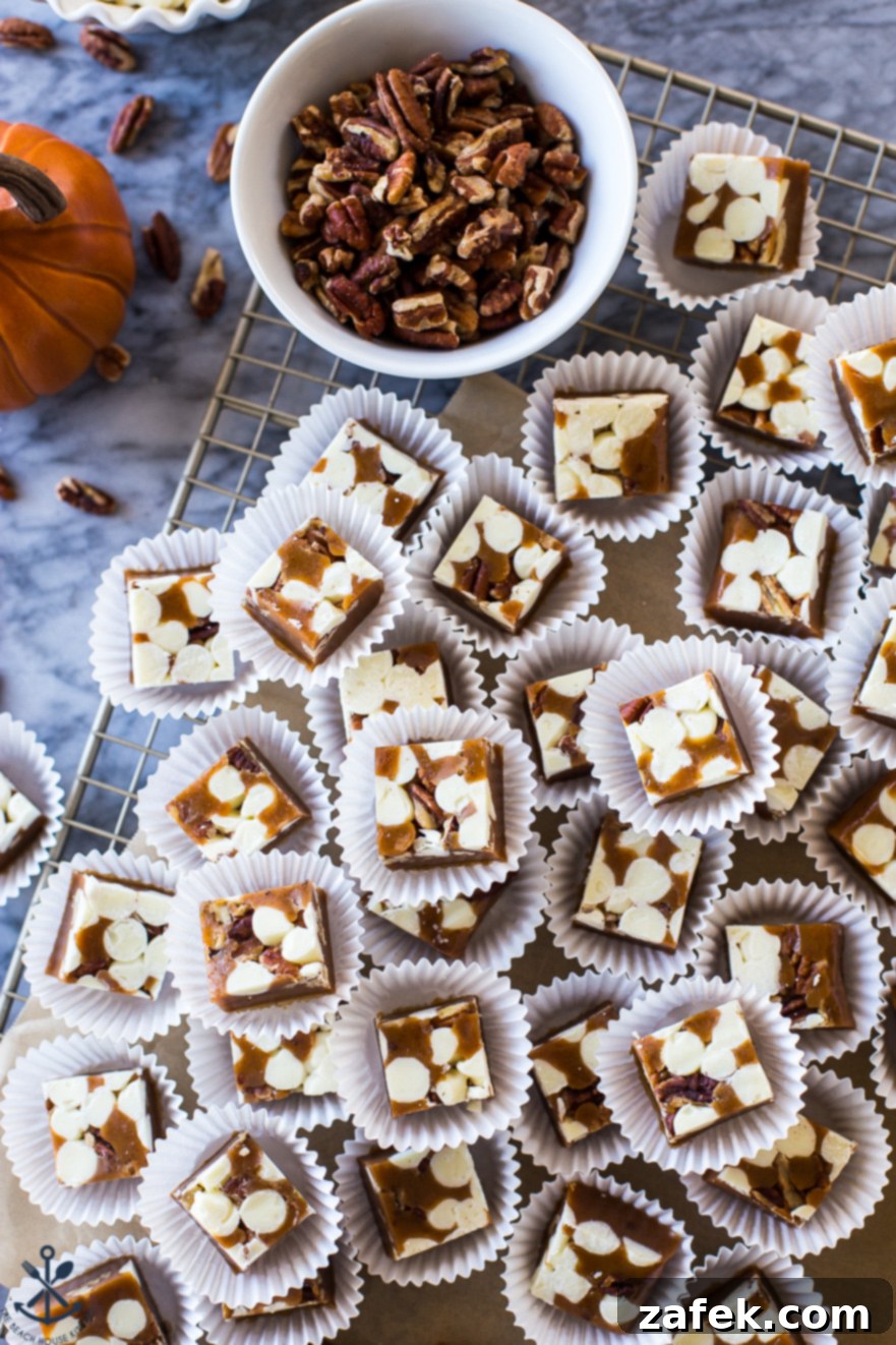 Overhead photo of Pumpkin Spice White Chocolate Pecan Caramels in white paper cups, showcasing their golden hue and inviting texture.
