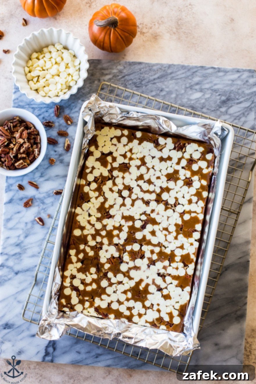 Caramels setting in a 9x13 pan on a white marble board, showcasing their rich, golden brown color before being cut.