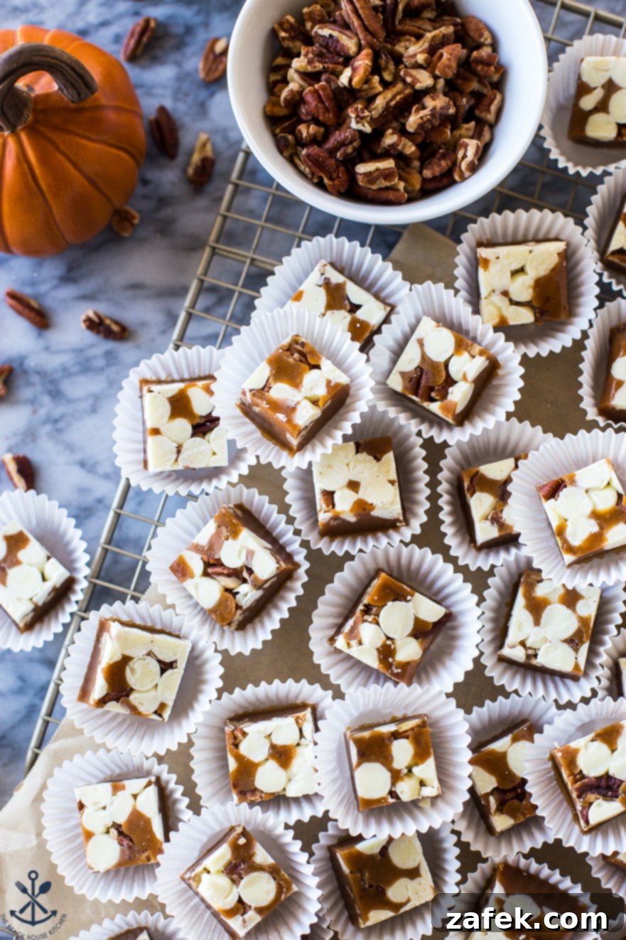 Pumpkin Spice White Chocolate Pecan Caramels displayed on a marble board next to a white dish filled with pecans, highlighting the ingredients.