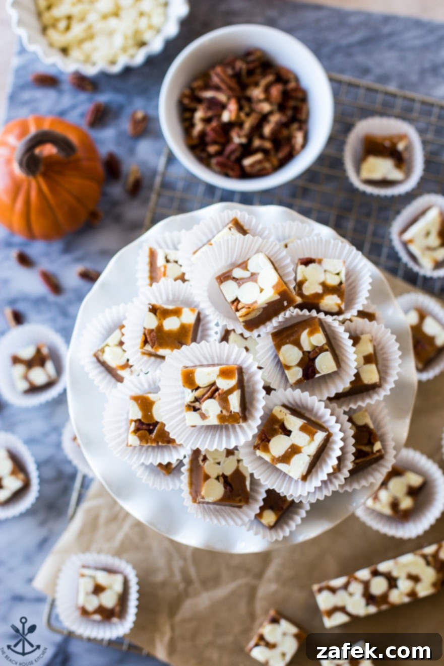 Overhead photo of perfectly cut caramels arranged on a white plate, with a small bowl of whole pecans beside them, emphasizing the fresh ingredients.