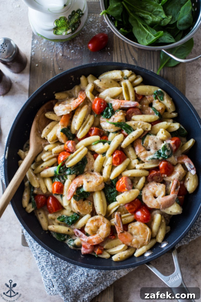 Creamy Garlic Shrimp Pasta with Sun-Kissed Tomatoes and Tender Spinach 2 Overhead photo of a generous portion of Shrimp Pasta with Garlic Cream Sauce, Tomatoes, and Spinach in a large skillet, ready to serve.
