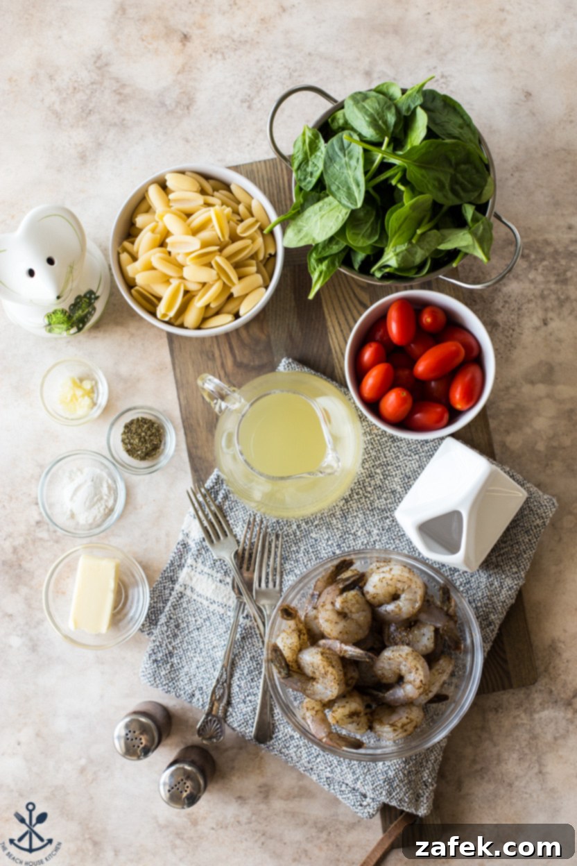 Creamy Garlic Shrimp Pasta with Sun-Kissed Tomatoes and Tender Spinach 4 Overhead flat lay photo showing all the fresh ingredients needed for Shrimp Pasta, including raw shrimp, pasta, grape tomatoes, spinach, garlic, butter, and seasonings laid out neatly.