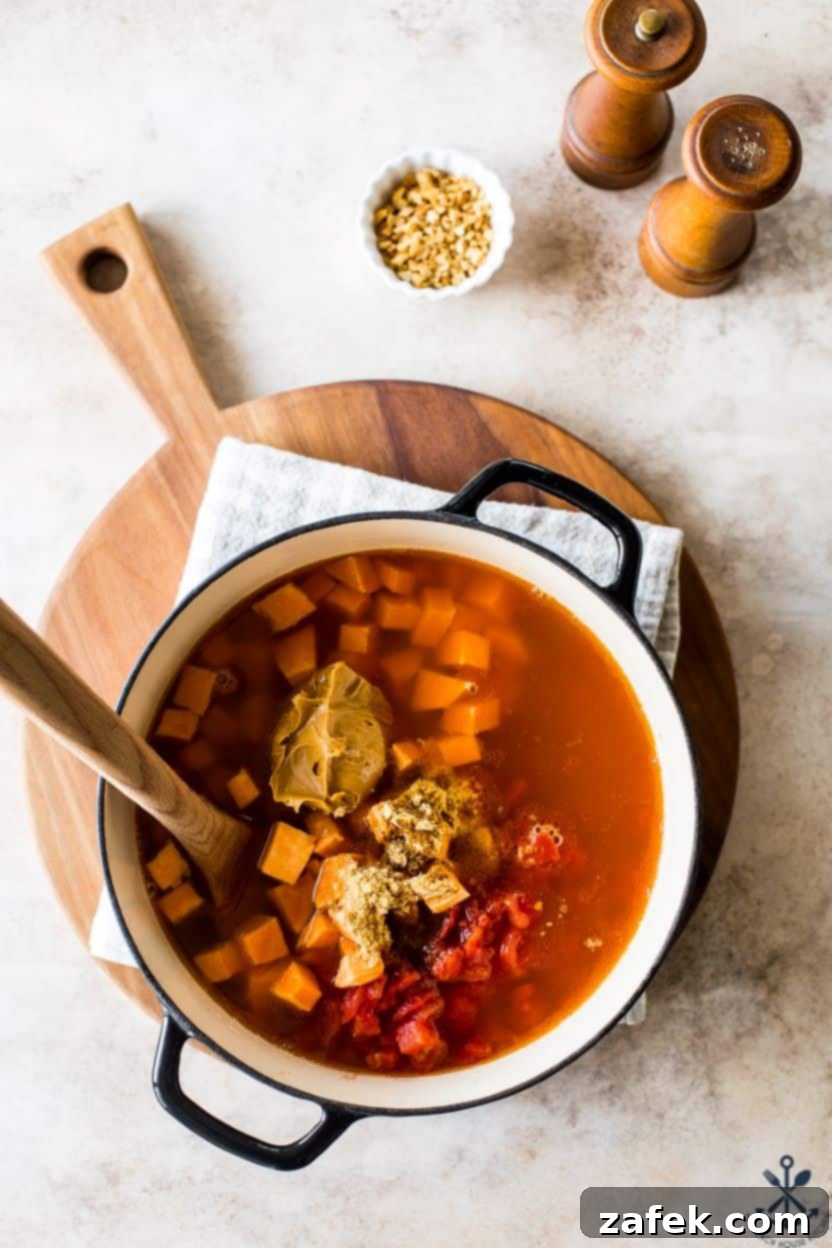 West African Peanut Sweet Potato Stew 5 Overhead photo of a pot of African peanut sweet potato stew simmering on the stovetop.