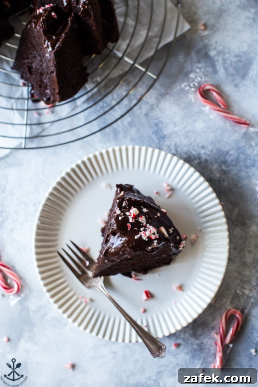 Peppermint Kissed Double Chocolate Decadence 3 Overhead photo of a slice of chocolate cake on a white plate with a fork