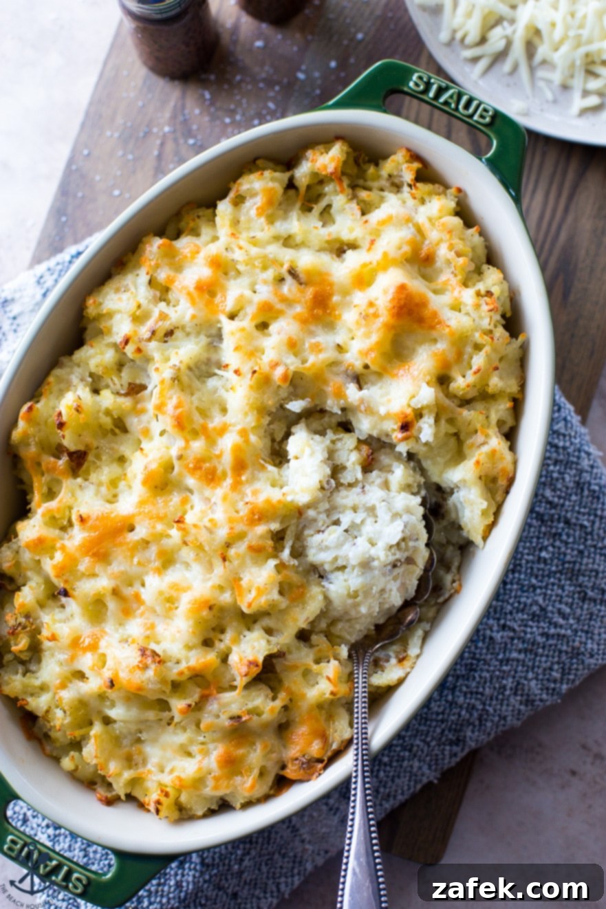 Overhead photo of cheesy potatoes in an oval dish