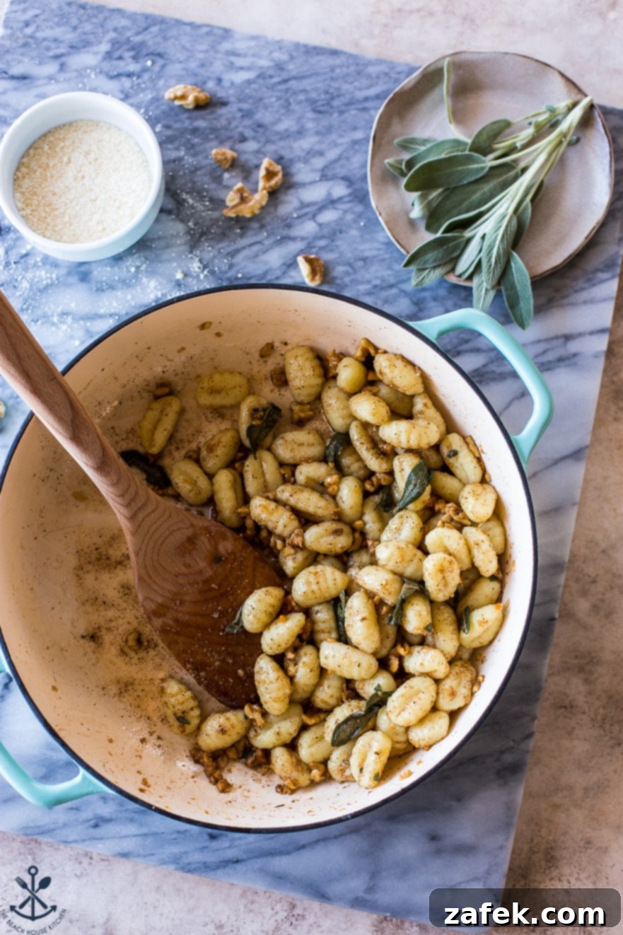 Sage-Kissed Gnocchi with Toasted Walnut Brown Butter 3 Pot filled with Gnocchi with Walnut Brown Butter Sage Sauce on a marble board