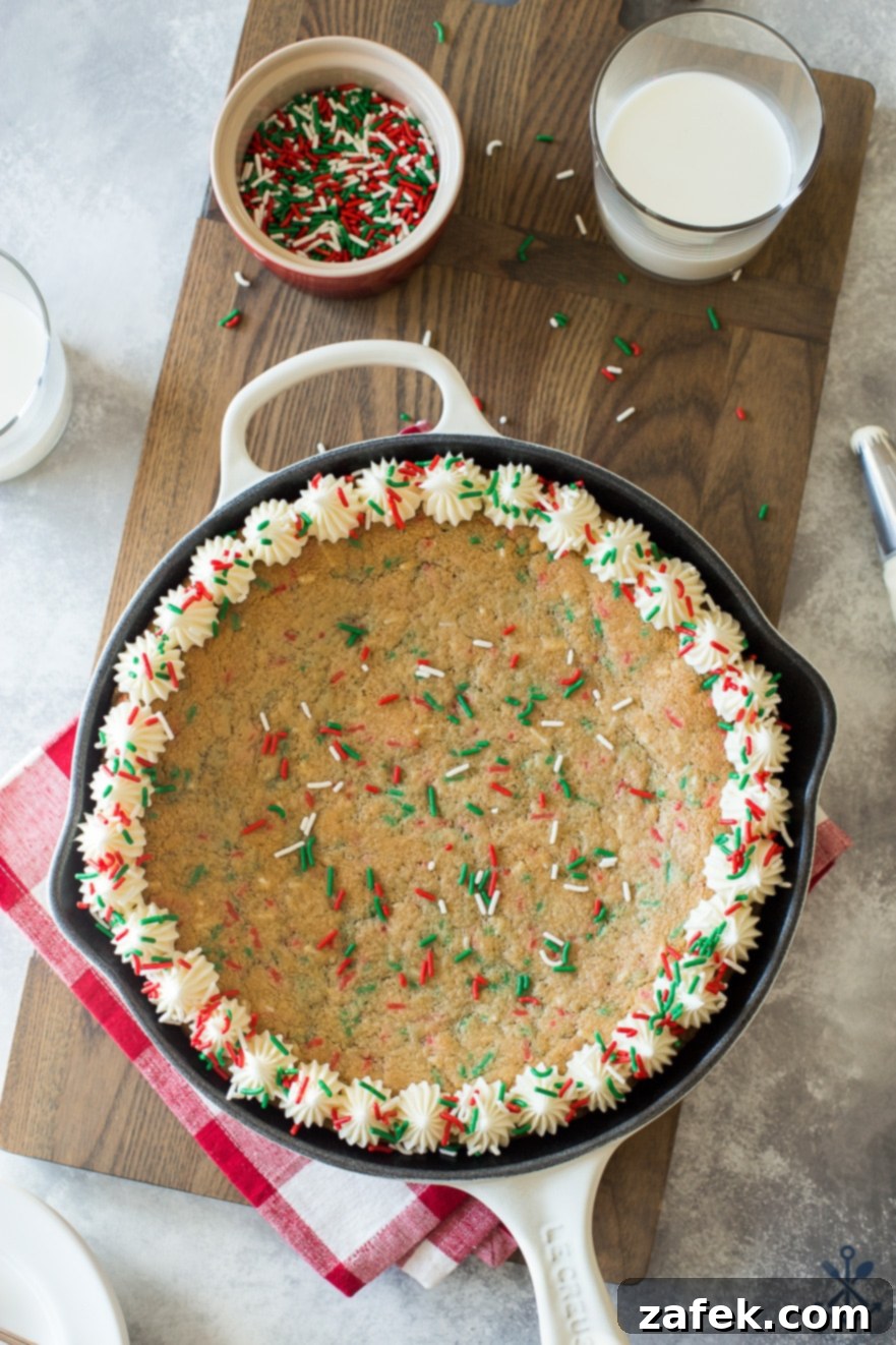 One-Pan Holiday Funfetti Cookie Bliss 3 Close-up overhead photo of a warm, golden-brown sugar cookie skillet with colorful sprinkles on a rustic wooden board