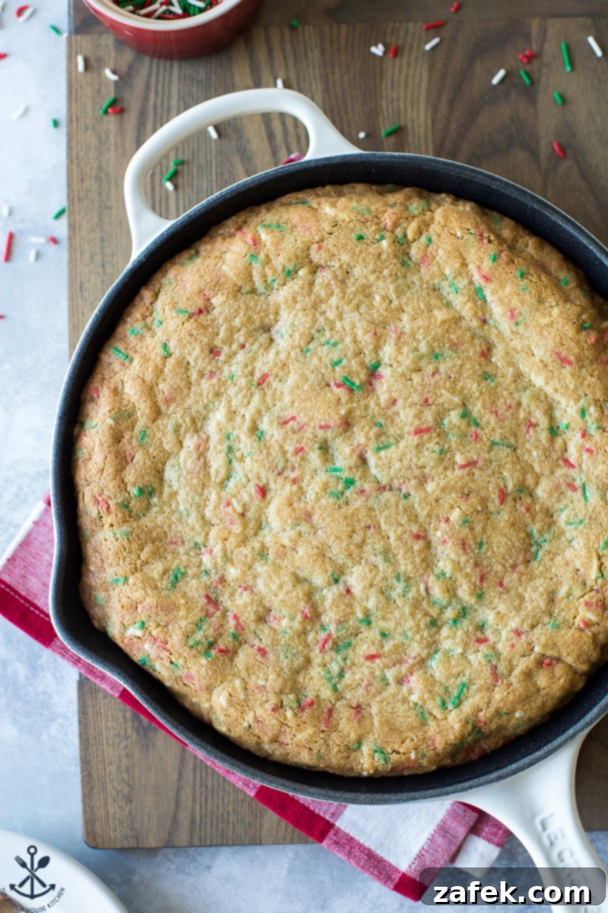 One-Pan Holiday Funfetti Cookie Bliss 5 Up close overhead photo of a freshly baked sugar cookie skillet, still warm and topped with a generous amount of colorful sprinkles, ready to be served