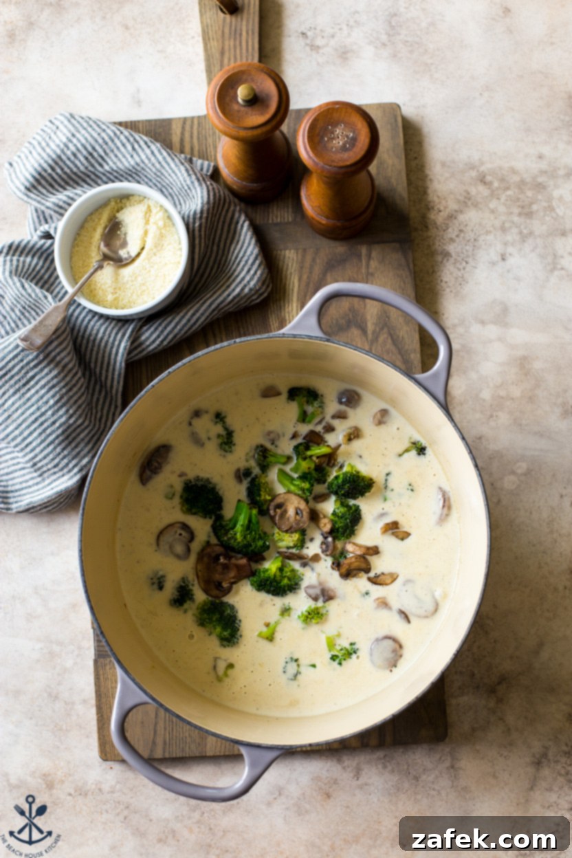Creamy Garlic Pasta with Broccoli and Mushrooms 6 Overhead photo of a pot filled with the creamy garlic sauce, mixed with perfectly cooked broccoli and mushrooms, creating a vibrant and appetizing blend.