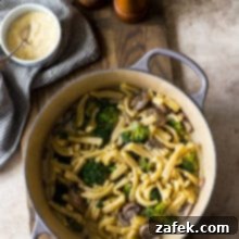 Creamy Garlic Pasta with Broccoli and Mushrooms 8 Overhead photo of a pot filled with Creamy Garlic Broccoli Mushroom Pasta on a wooden board