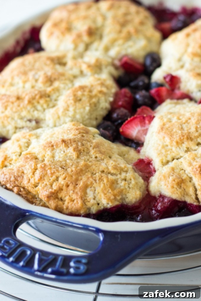 Serving Berry Cobbler with Sweet Biscuit Topping alongside vanilla ice cream