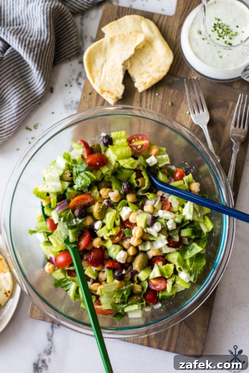 Zesty Green Goddess Greek Chickpea Salad 2 Overhead photo of a glass bowl filled with a Greek salad