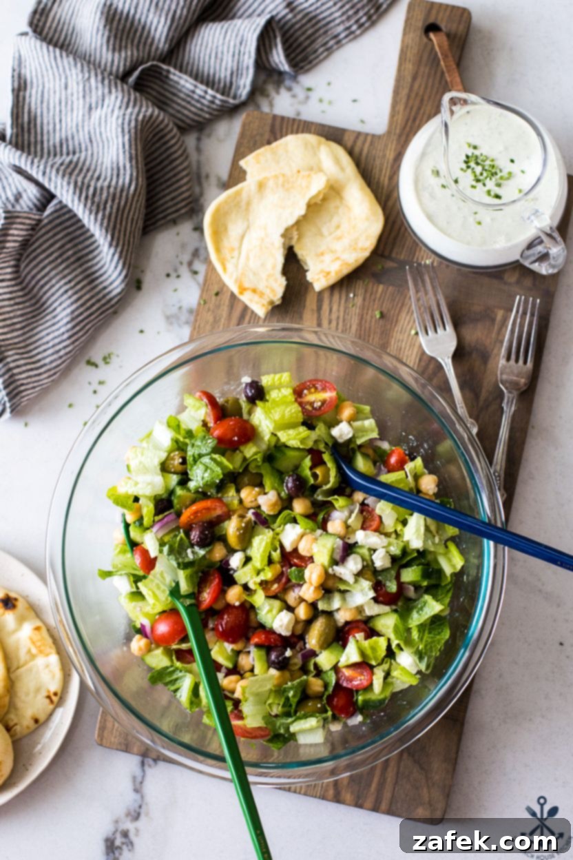 Zesty Green Goddess Greek Chickpea Salad 7 Overhead photo of a Greek Chickpea Salad with Green Goddess Dressing in a glass bowl