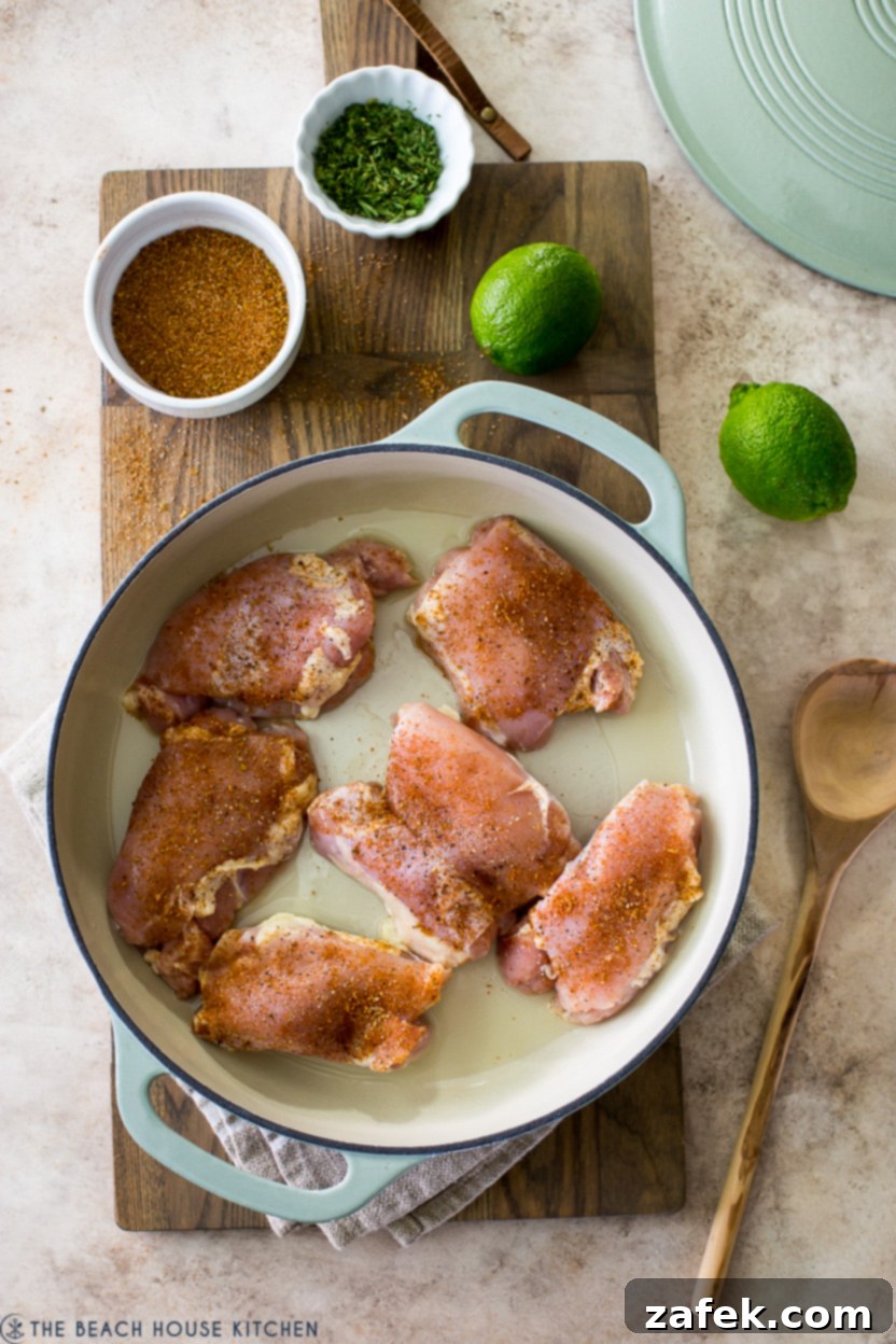 Overhead photo of a skillet of uncooked chicken thighs