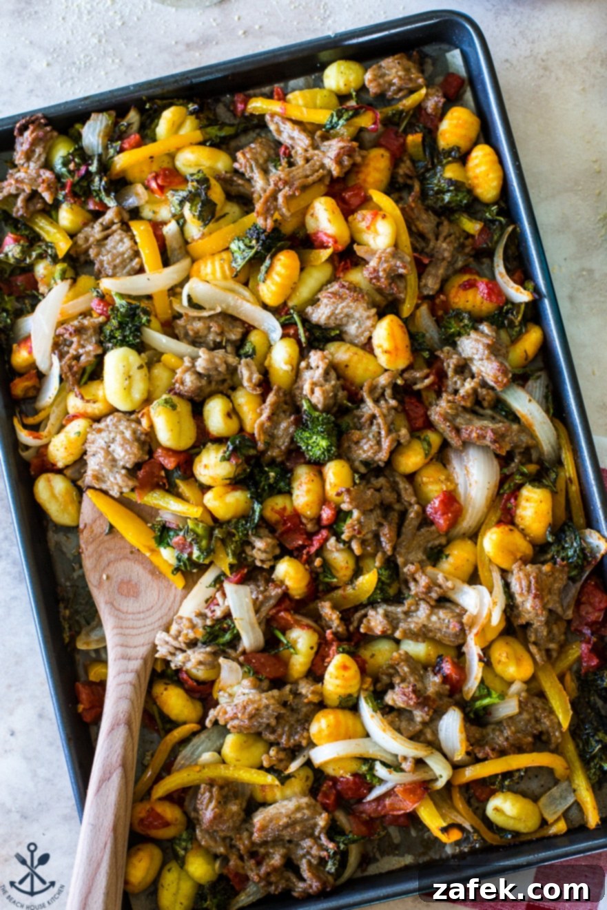 Up close overhead photo capturing the vibrant colors and textures of the cooked Sheet Pan Gnocchi with Italian Sausage, Broccoli Rabe, Onions, and Peppers, ready to be enjoyed.