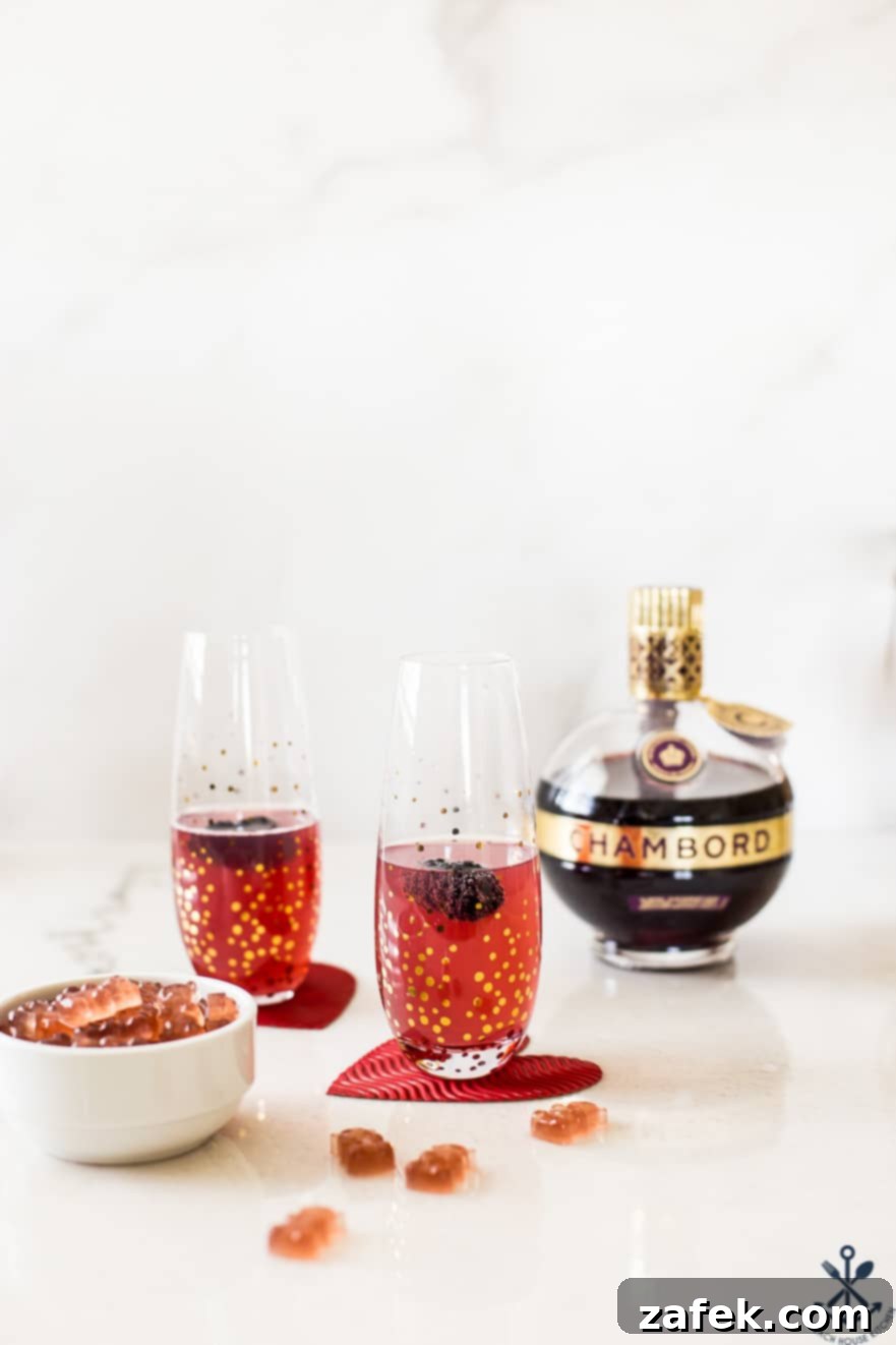 Chambord Fizz cocktail and Chambord boozy gummies with a Chambord bottle in the background, set for a festive occasion.