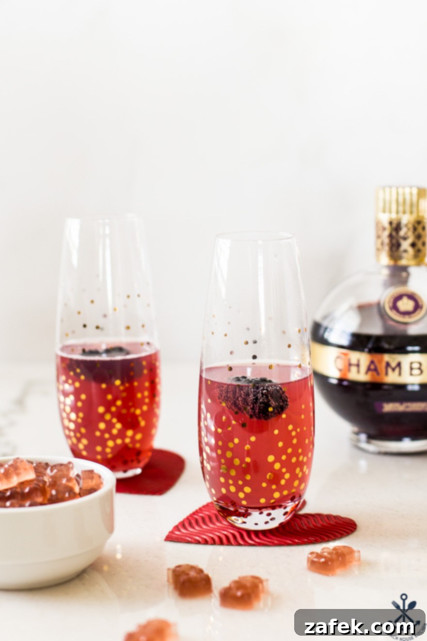Close-up of a Chambord Fizz cocktail garnished with a blackberry, alongside a bowl of shimmering Chambord boozy gummies, hinting at their deliciousness.