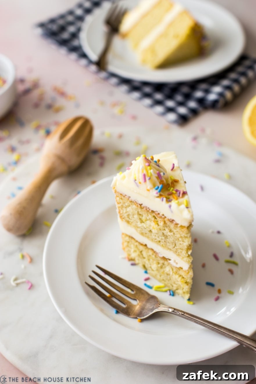 A perfectly sliced piece of lemon cake on a white plate