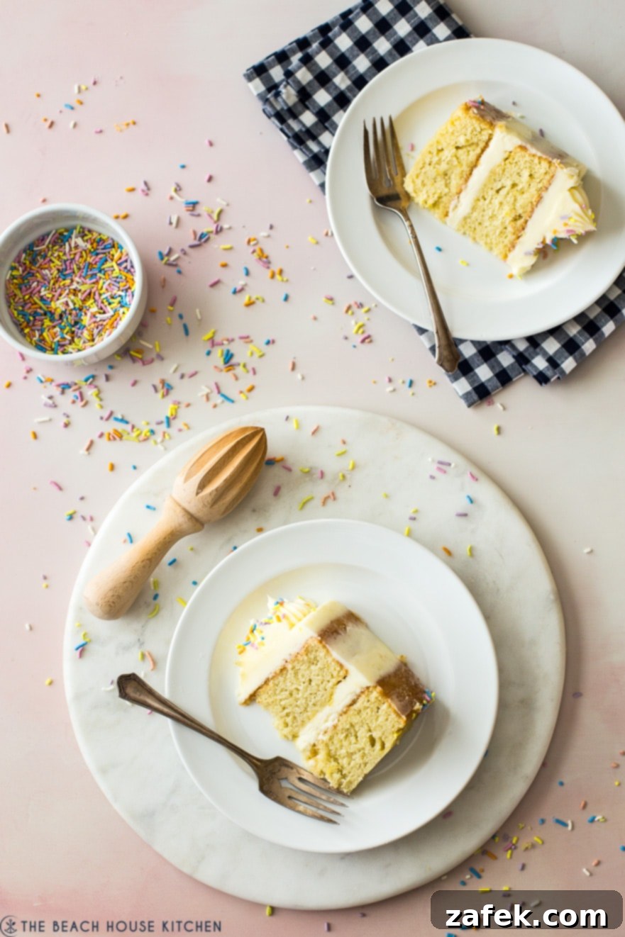 Overhead shot of lemon cake slices on plates with forks and a small bowl of pastel sprinkles