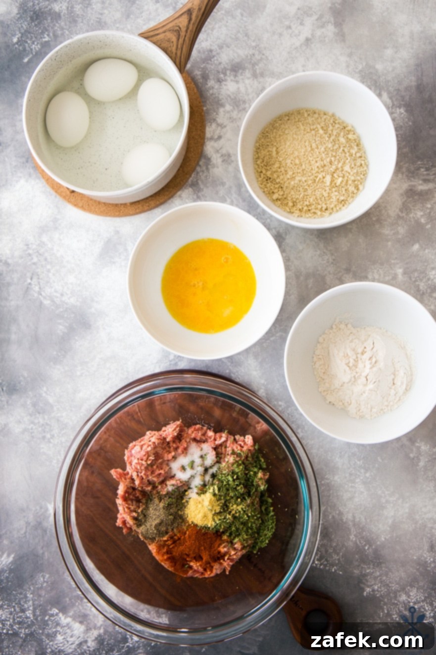 Overhead photo of ingredients for scotch eggs in bowls on a gray background