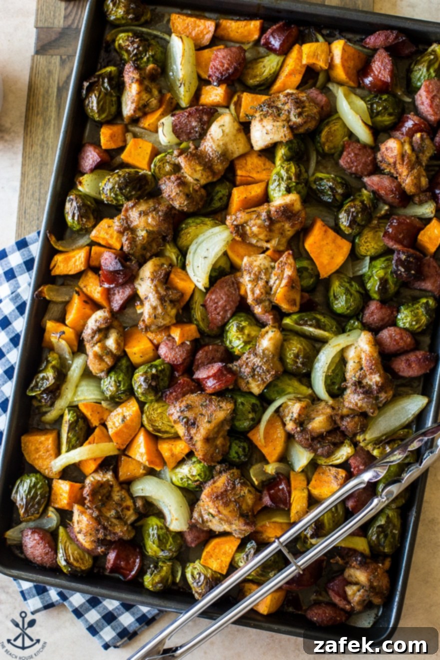 Overhead close-up photo of perfectly cooked chicken thigh sheet pan dinner with caramelized sweet potatoes and roasted Brussels sprouts