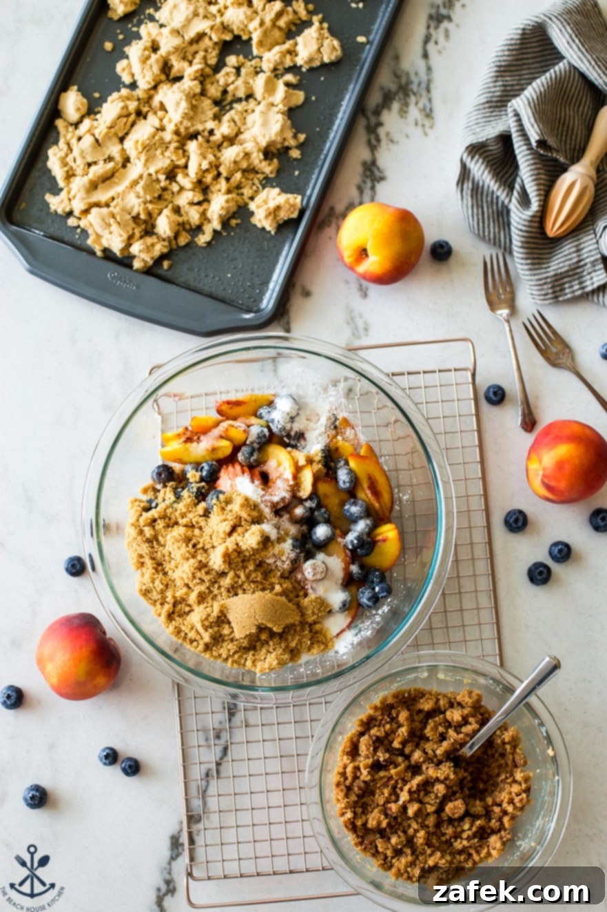 Sweet Summer Peach Blueberry Crumble Slab 4 Overhead photo of various ingredients for Peach Blueberry Streusel Slab Pie, including fresh peaches, blueberries, flour, sugar, and butter, laid out on a table and in bowls.