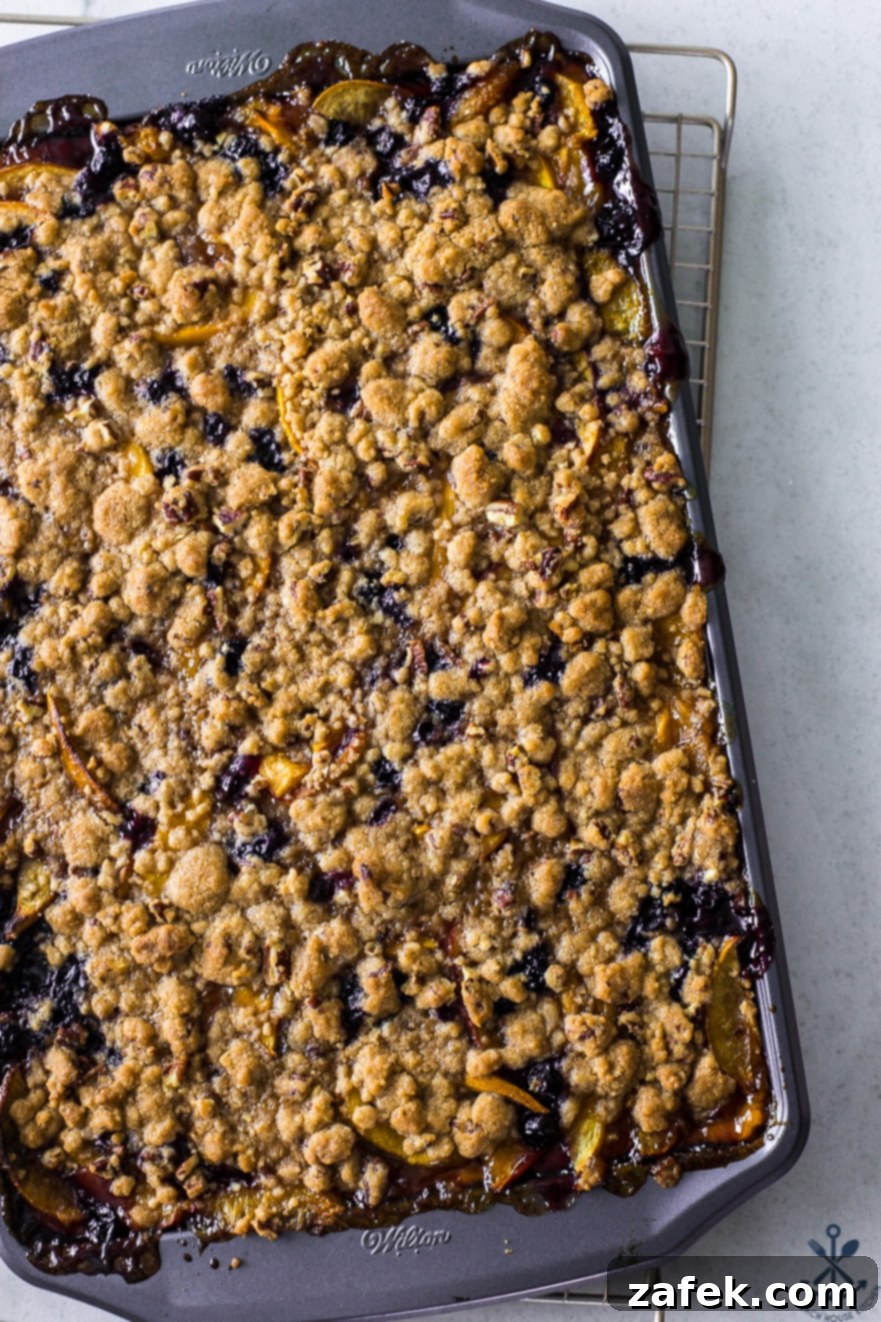 Sweet Summer Peach Blueberry Crumble Slab 5 Close-up overhead photo of a slice of Peach Blueberry Streusel Slab Pie, showing the golden crust, fruit filling, and streusel topping.