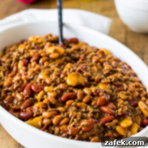 Hearty Three-Bean Casserole 7 Baked Three Bean Casserole served in a white bowl with a spoon