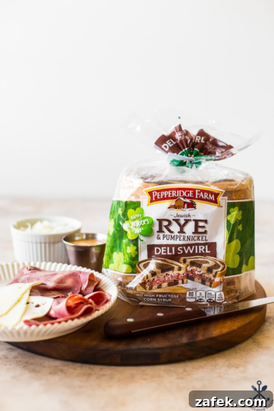 A deli setup featuring a fresh bag of Pepperidge Farm Rye & Pumpernickel Deli Swirl bread, a sharp knife, and a plate with thinly sliced corned beef and Swiss cheese on a rustic wooden board.