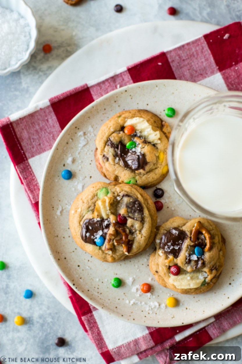 Kitchen Sink Cookies 2 Overhead photo of a plate of three kitchen sink cookies with a glass of milk, highlighting their varied textures
