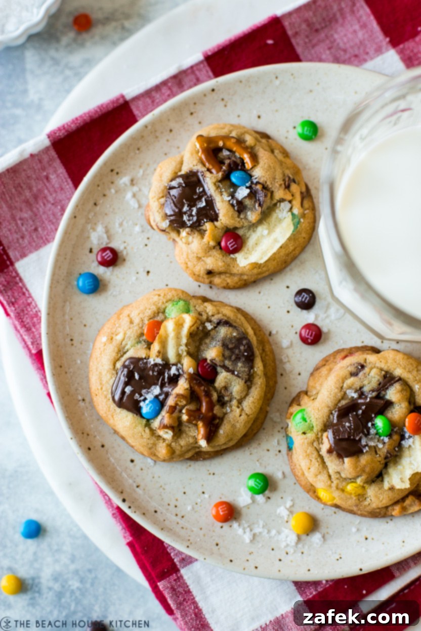 Kitchen Sink Cookies 7 Up close overhead photo of a plate of three enticing kitchen sink cookies, showing off their rich texture and colorful mix-ins