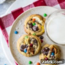Kitchen Sink Cookies 8 Overhead photo of three cookies on a plate with a glass of milk on a red check napkin