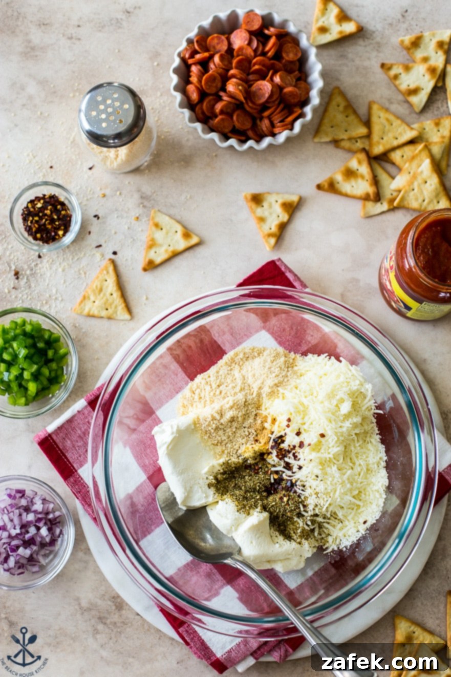 Overhead photo of ingredients for pepperoni dip in bowls of different size