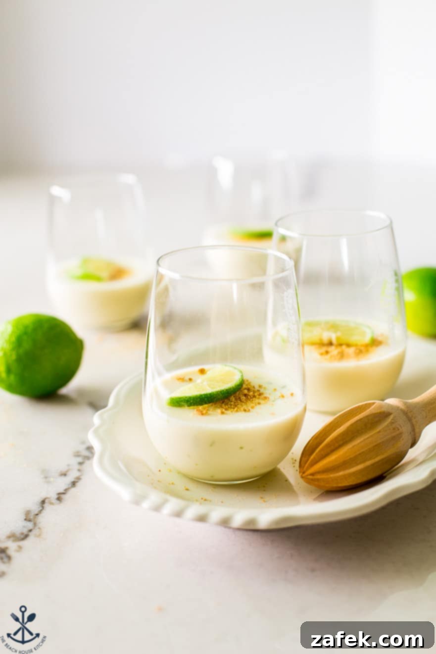Zesty Key Lime Panna Cotta 6 Glasses of key lime panna cotta on a white oval plate with a wooden juicer