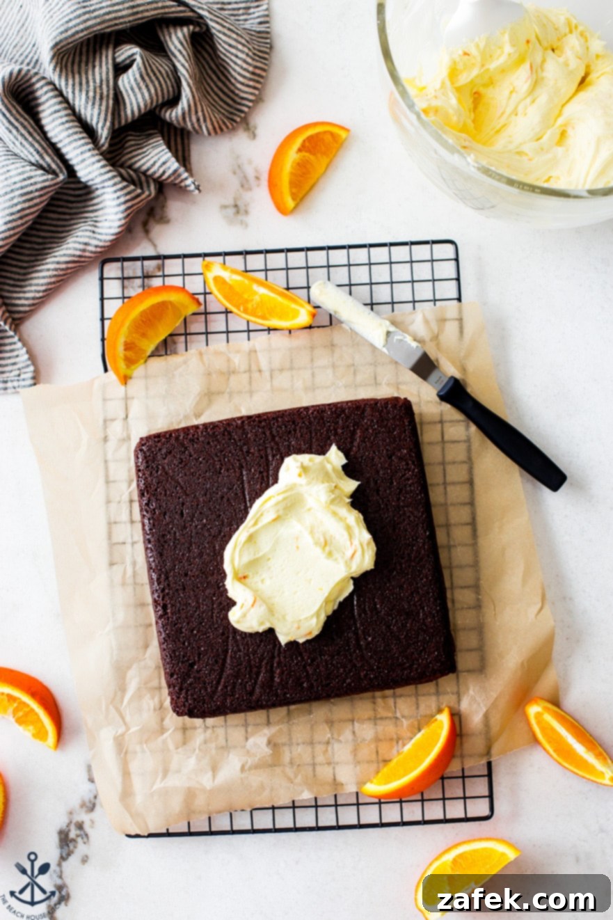 Overhead photo of a pre-iced square chocolate cake cooling on a wire rack, ready for the delicious orange buttercream