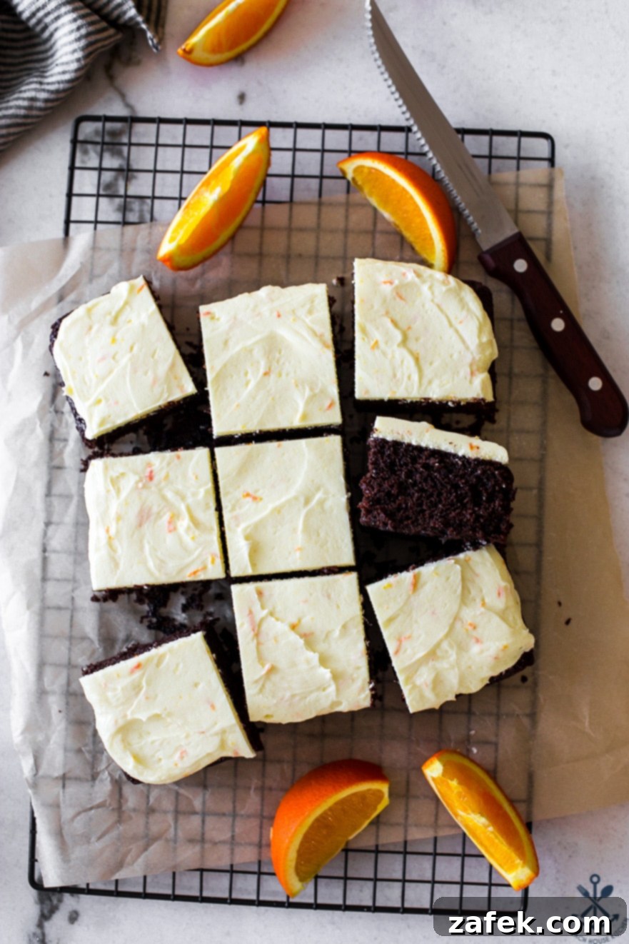 Overhead photo of chocolate cake slices with orange buttercream and a sharp knife on the side, showcasing the beautiful texture and frosting