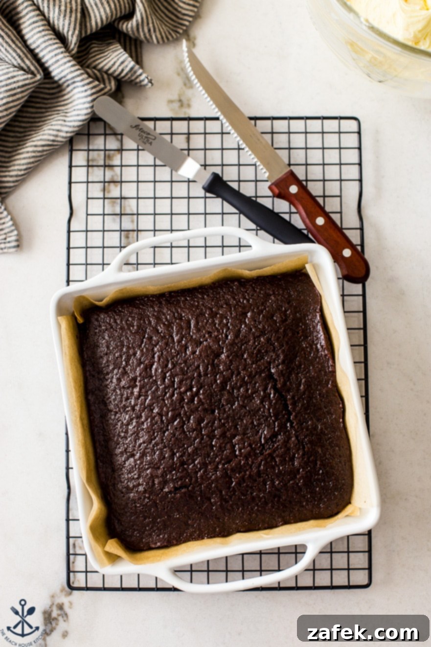Overhead photo of chocolate snack cake on a wire rack with cutlery next to the tray, invitingly presented