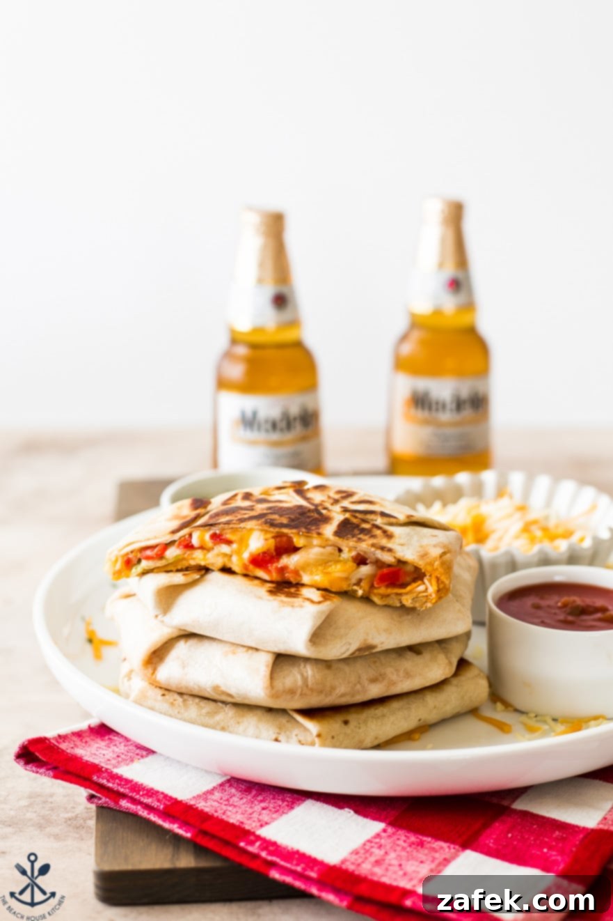 Buffalo Chicken Ultimate Crispy Wraps 7 A perfectly stacked trio of Buffalo Chicken Crunchwrap Supremes on a white serving platter, with blurred cold beers in the background, signaling a celebratory or casual dining experience.