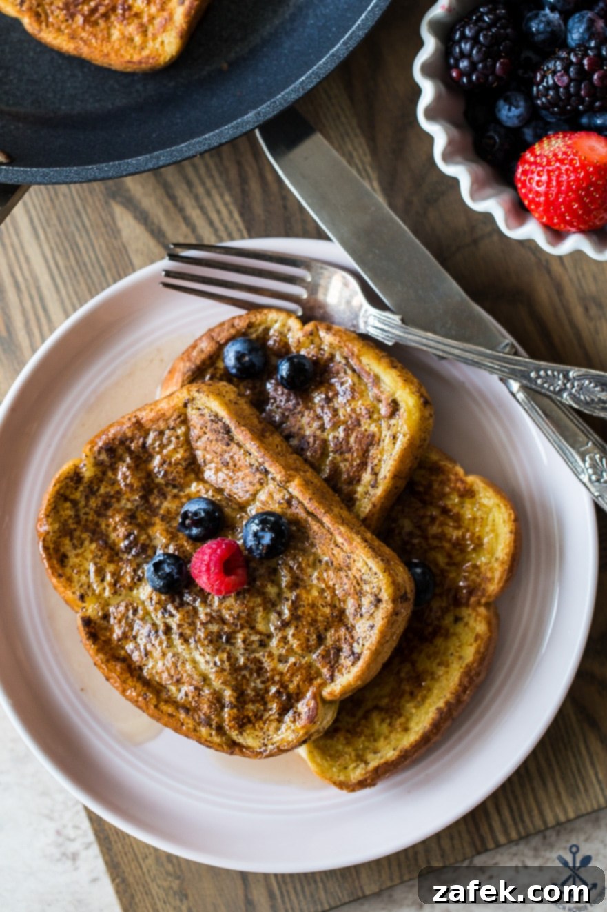 Aromatic Chai French Toast 4 Up close overhead photo of three slices of french toast topped with berries