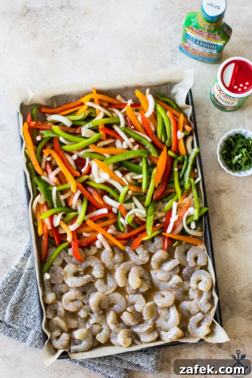 Effortless Sheet Pan Shrimp Fajitas 9 Overhead photo of a sheet pan filled with uncooked shrimp, onions and peppers