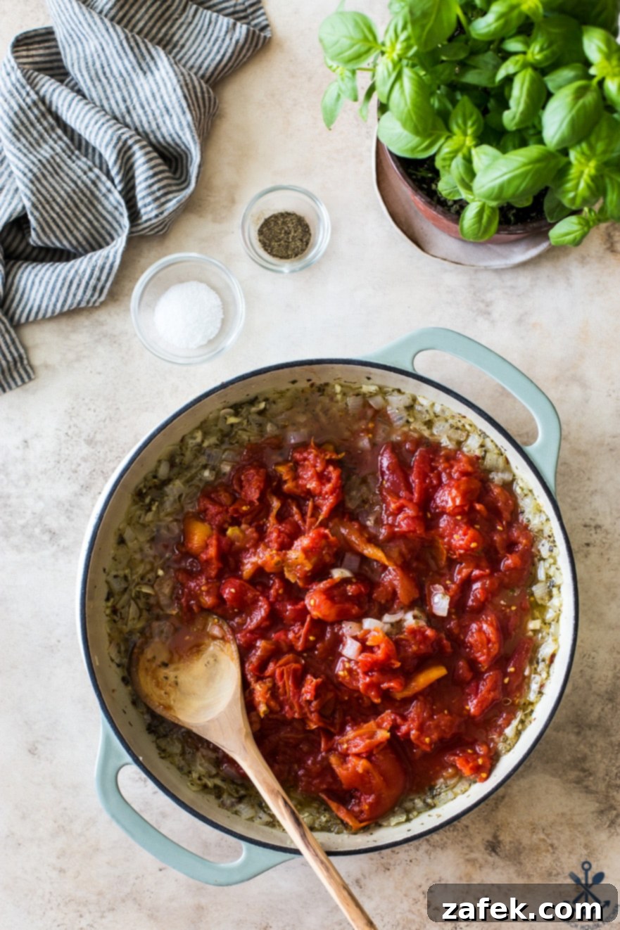 Pink Sauce Penne 4 Overhead photo of a round ceramic baking dish brimming with whole peeled San Marzano tomatoes, before being roasted